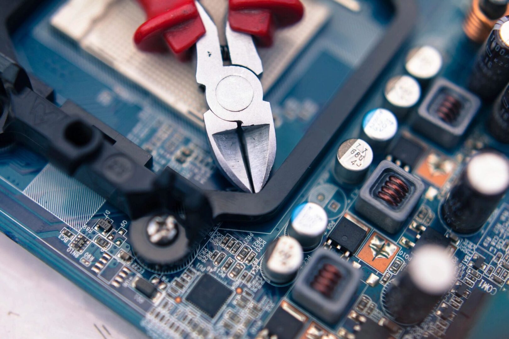 A pair of pliers sitting on top of a circuit board.