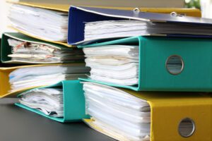 Pile of different file folders or ring binders full with office documents and paper work