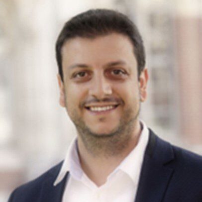 Smiling man in a suit jacket.